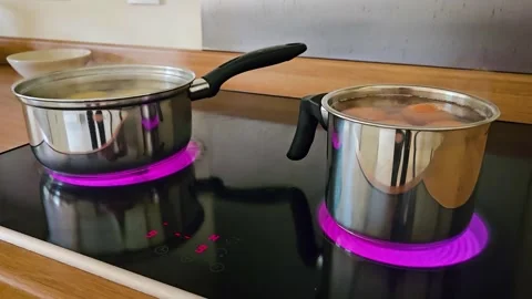 Boiling Potatoes and Eggs in Cauldrons on Electric Stove in Warm Kitchen Setting Stock Footage 303369397