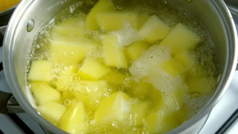Boiling potatoes in saucepan cooking mashed potato puree on kitchen. Stock Footage 312402546
