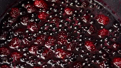 Boiling raspberry and blueberry sauce in a pot. Stock Footage 141931495