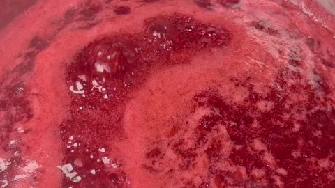 Boiling red jam is cooked in a saucepan. Air bubbles and steam slowly come .. Video stock 244875036