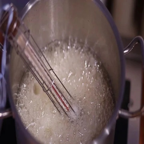 Boiling sugar caramel with thermometer in the pan Stock Footage 69456225