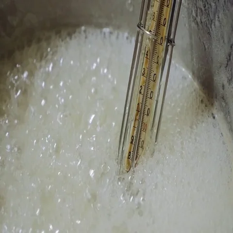 Boiling sugar caramel with thermometer in the pan Stock Footage 69478025