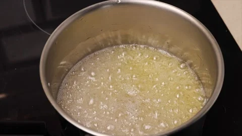 Boiling sugar to make syrup for desserts. Thick, bubbling syrup perfect Stock Footage 301800552