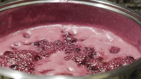 Boiling sweet pink cherry jam with sugar is being prepared on the stove Stock Footage 244863986