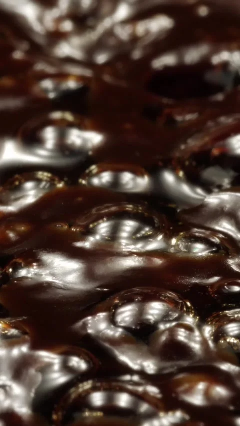 Boiling thick dark liquid with glossy surface and bubbles. Vertical video. Stock Footage 300311438