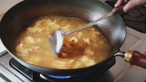 Boiling Tomato and Egg Soup in a Traditional Iron Wok Stock Footage 346306219