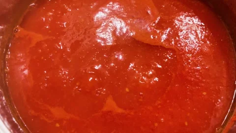 Boiling tomato sauce cooks inside a metal pan on the kitchen stove.  Stock Footage 348447003