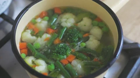 Boiling vegetables green broccoli, white cauliflower, orange carrot, green beans Stock Footage 169858843