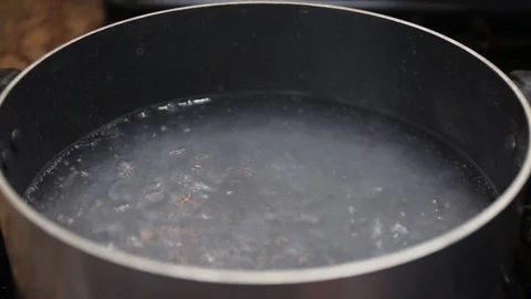 Boiling water in black pan Stock Footage 89178984