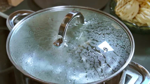 Boiling water bubbles in a pot with a glass lid. Slow motion video 100fps. Stock Footage 308084588