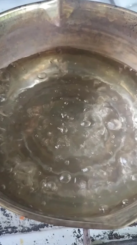 Boiling water bubbling in open pot close up Stock Footage 323574099
