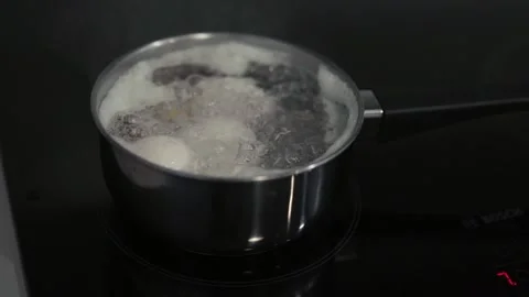 Boiling water with eggs in a kitchen.	 Stock Footage 311806422