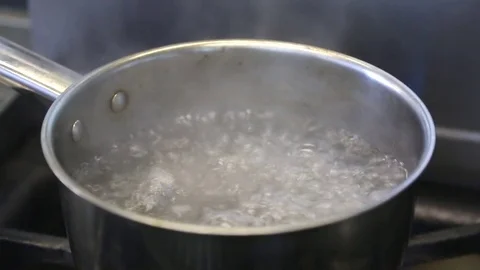 Boiling water in a kitchen pot as a symbol of cooking or food preparation Stock Footage 83590901