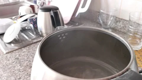 Boiling water in metal kettle selective focus. Water vapor comes out Stock Footage 213967425