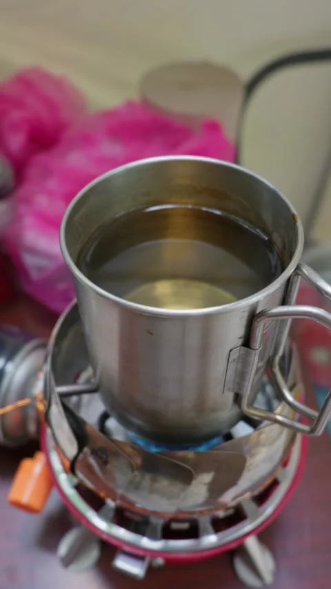 Boiling Water in Metal Mug Heating on Portable Gas Camping Stove Stock-Footage 341995623