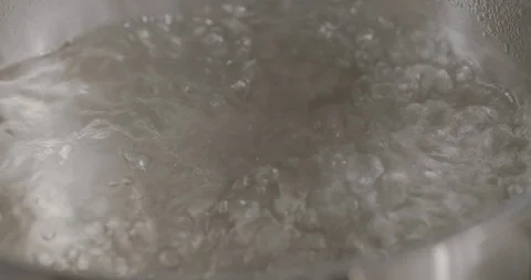 Boiling water in a metal pot in kitchen, closeup. Top View Stock Footage 124005399