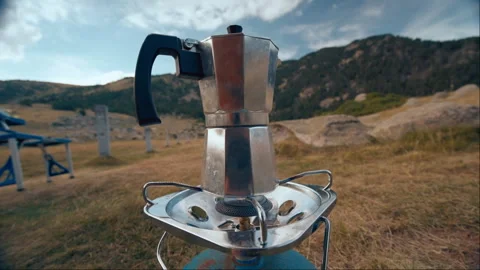 Boiling water on mountain vacation trip in moka pot outdoor in camping Stock Footage 256807992
