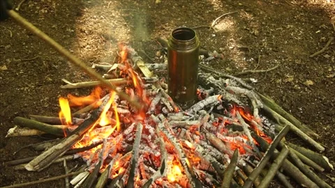 Boiling Water over the Campfire. Boiling Water in Metal Bottle for Survival Stock Footage 306871410