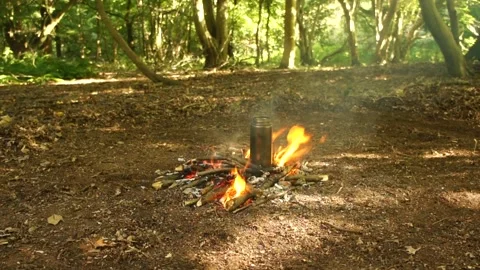 Boiling Water over the Campfire. Boiling Water in Metal Bottle for Survival Stock Footage 306871907