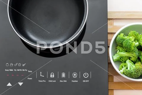 Boiling water at pan on Induction stove top panel Stock Photos