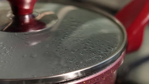 Boiling water in a pot with a cap Stock Footage 129090353