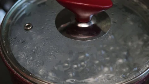 Boiling water in a pot with a cap Stock Footage 129090358
