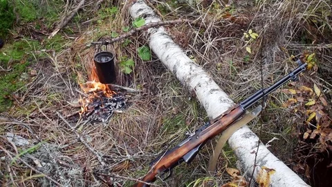 Boiling water in pots above the fire in outdoor. Hunter shotgun Stock Footage 70742629