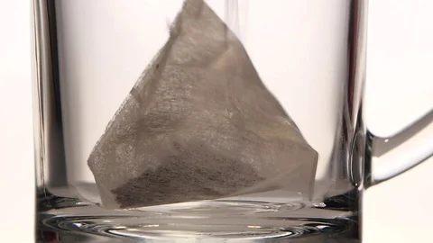 Boiling water is poured in cup with pyramid tea bag Stock Footage 73854380