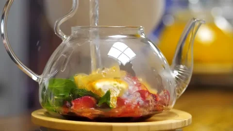 Boiling water is poured into a kettle with fruit, mint and berries 스톡 동영상 201092069