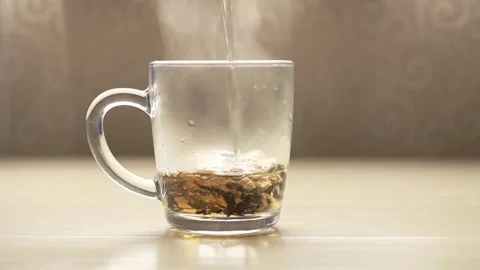 Boiling water is poured into a mug with dry black tea Stock Footage 158300044