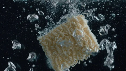 In the boiling water throw vermicelli. Video in slow motion Stock Footage 111692278