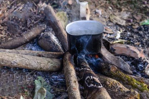 Boiling water using bonfire on vacation at campsite. Stock Photos