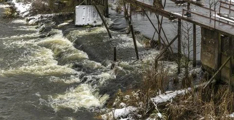 Boiling water in a winter river under a pedestrian bridge. Abstract backgroun Foto stock
