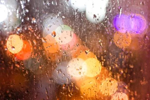 Bokeh background of rain drops on window  from the lights of a night city. Stock Photos