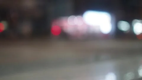 Bokeh blurred background vehicles passing by on street at night low angel shot. Stock Footage 280896501