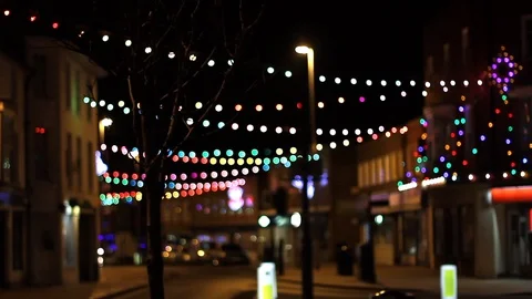 Bokeh Effect on String Christmas Lights Over Quiet Street at Night Vídeo Stock 94472369