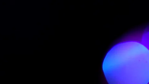 Bokeh of flashing light with red to blue color shift on the right Видео 309426730