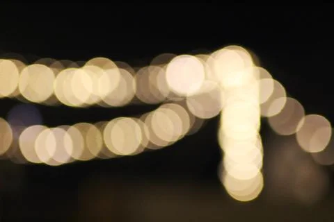 A bokeh image of shimmering golden string lights on a dark background, crea.. Fotos de archivo