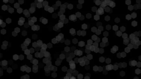 Bokeh light effects, defocused hexagonal shapes floating against a solid black Stock Footage 319996348