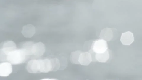 Bokeh light reflected on the water surface in small waves. glittering in sunligh Stock Footage 229402206