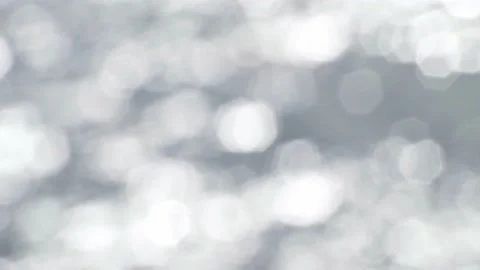 Bokeh light reflected on the water surface in small waves. glittering in sunligh Stock Footage 229402207