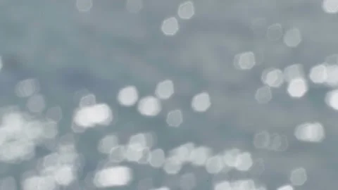 Bokeh light reflected on the water surface in small waves. glittering in sunligh Stock Footage 229402220