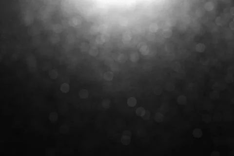 Bokeh of lights on black background with light spot on center top for overlay on Stock Photos