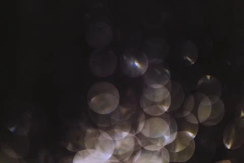 Bokeh of lights made by raindrops on a windows illuminated by a torch Stock Photos