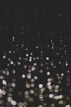 Bokeh of lights made by raindrops on a windows illuminated by a torch Stock Photos