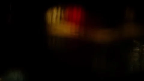 Bokeh lights through a wet window in the rain of cars driving past Stock Footage 334312118