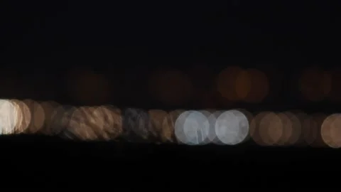 Bokeh patterns created by oncoming headlights in the evening Stock Footage 155940760