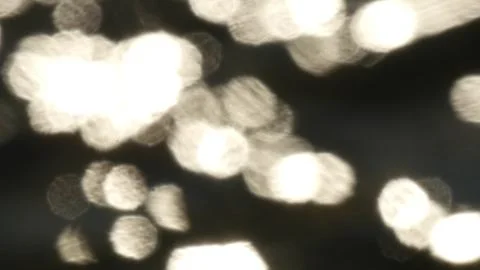 Bokeh sun glare reflected in water surface. Abstract flickering background. Stock Photos