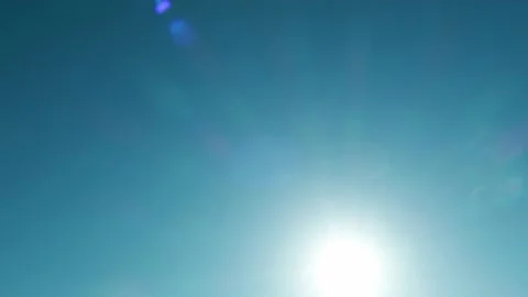 Bokeh sun light ray n bright sunbeam lens flare on cyan blue sky Video stock 161634566