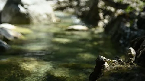 Bokeh of sunlight effects on a stony mountain stream in summer (slow motion) Stock Footage 262089651